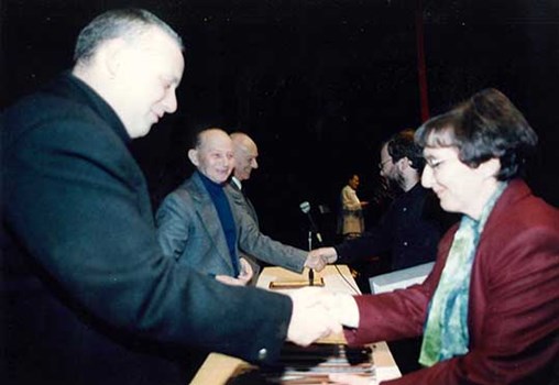 Rachel Galinne receiving the ACUM (The Israel Society of Authors, Composers, Lyricists, Poets, Arrangers and Music Publishers) Prize for her work "And We Shall Sing My Songs of Praise". In the background: the music critic Natan Mishori and The conductor Mendi Rodan, 1994 (Call no. MUS 253 i-21)