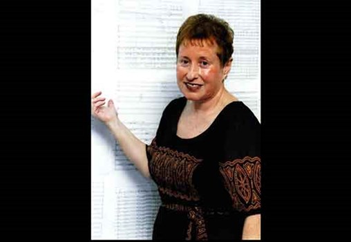 ציפי פליישר על רקע דפי הפרטיטורה של הסימפוניה החמישית "קולאז' ישראלי-יהודי" באירוע להשקת התקליטור (2004)