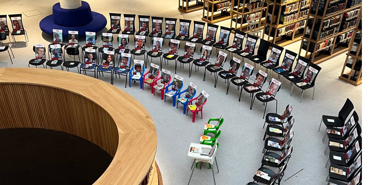 a display of chairs withe books on them, each represent a hostage 